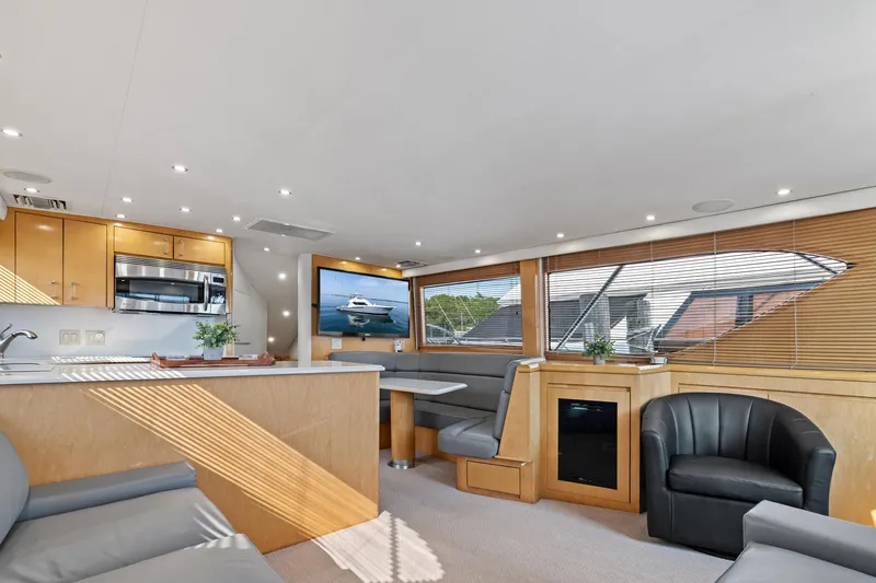 Amp'd Up Yacht Photos Pics Luxurious interior of 1999 Hatteras 60 Convertible yacht with modern kitchen and seating area.