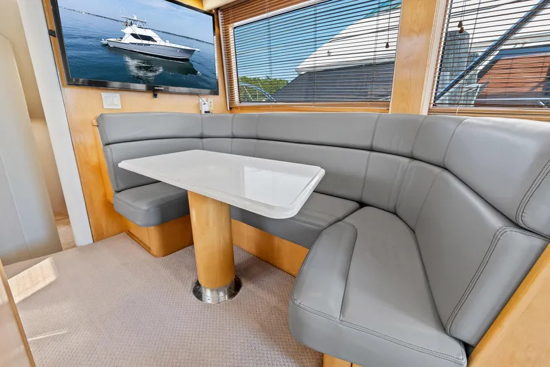 Amp'd Up Yacht Photos Pics Luxurious interior of 1999 Hatteras 60 Convertible yacht with gray seating and a TV.