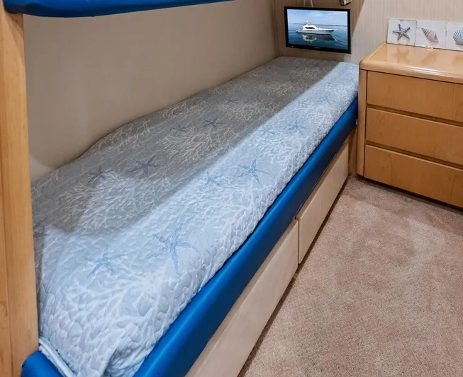 Amp'd Up Yacht Photos Pics Cozy cabin interior of 1999 Hatteras 60 Convertible yacht with bed and wooden dresser.