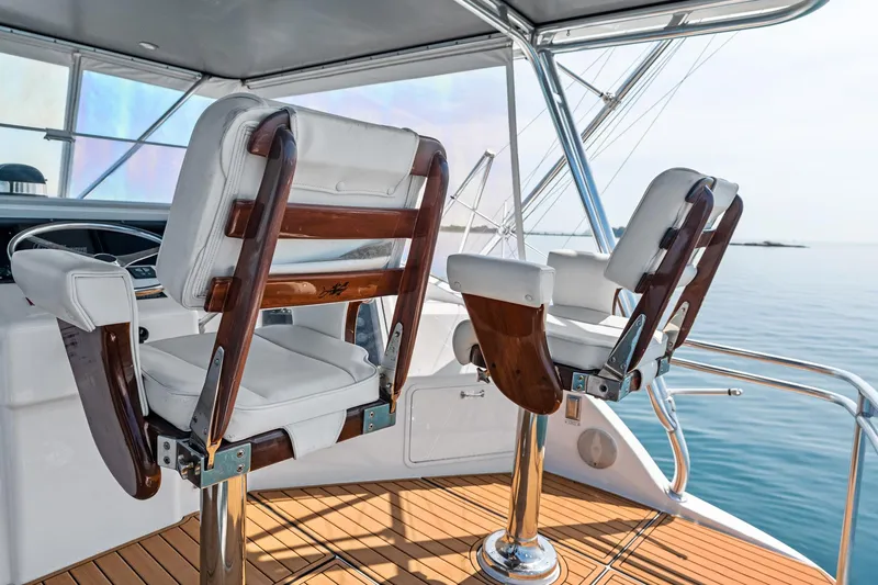 Amp'd Up Yacht Photos Pics Captain's chairs on 1999 Hatteras 60 Convertible yacht, overlooking calm ocean waters.