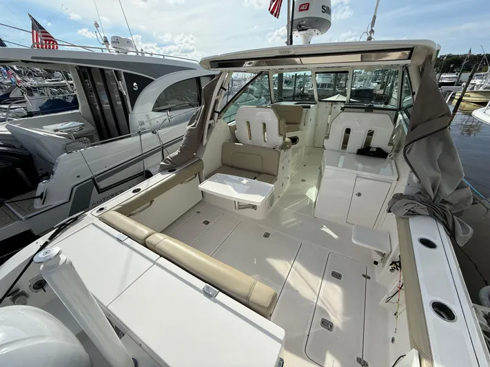  Yacht Photos Pics 2017 Pursuit DC 325 Dual Console boat interior with seating and storage, docked at marina.