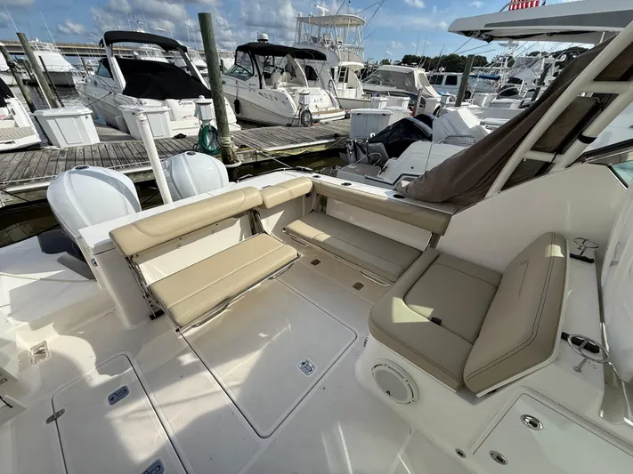  Yacht Photos Pics 2017 Pursuit DC 325 Dual Console boat interior with beige seating at marina.