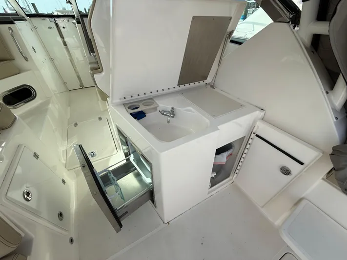  Yacht Photos Pics 2017 Pursuit DC 325 Dual Console boat interior with sink and storage compartments.