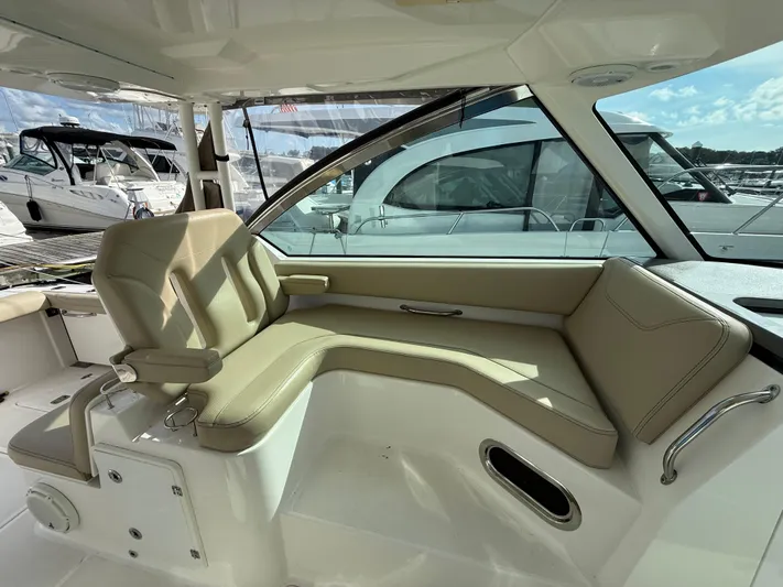  Yacht Photos Pics 2017 Pursuit DC 325 Dual Console interior with beige seating, docked at marina.