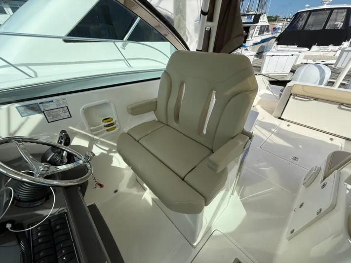 Yacht Photos Pics Captain's chair on 2017 Pursuit DC 325 Dual Console boat, featuring steering wheel and controls.