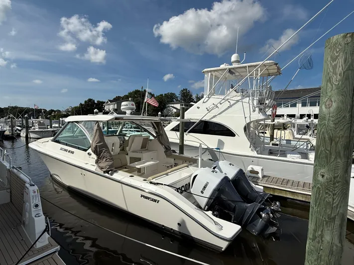  Yacht Photos Pics 2017 Pursuit DC 325 Dual Console boat docked at marina under blue sky.