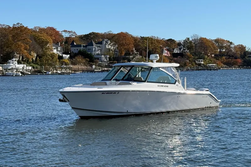  Yacht Photos Pics 2017 Pursuit DC 325 Dual Console boat cruising on a scenic lake.