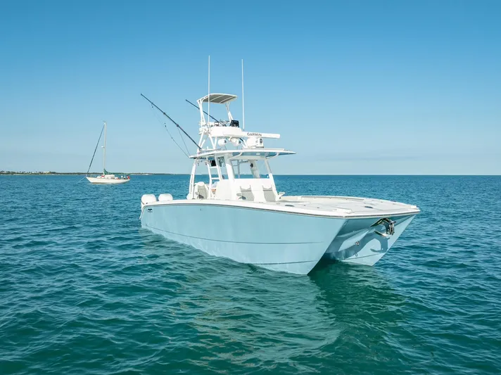  Yacht Photos Pics 2023 Invincible 37 Catamaran on calm blue ocean waters under clear sky.