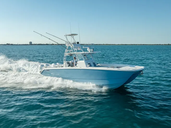  Yacht Photos Pics 2023 Invincible 37 Catamaran cruising on open water under clear blue sky.
