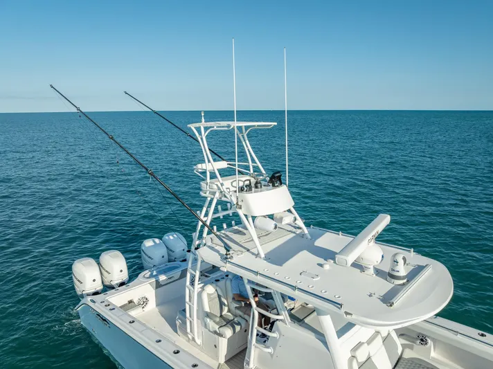  Yacht Photos Pics 2023 Invincible 37 Catamaran on open sea, featuring multiple outboard engines and fishing rods.
