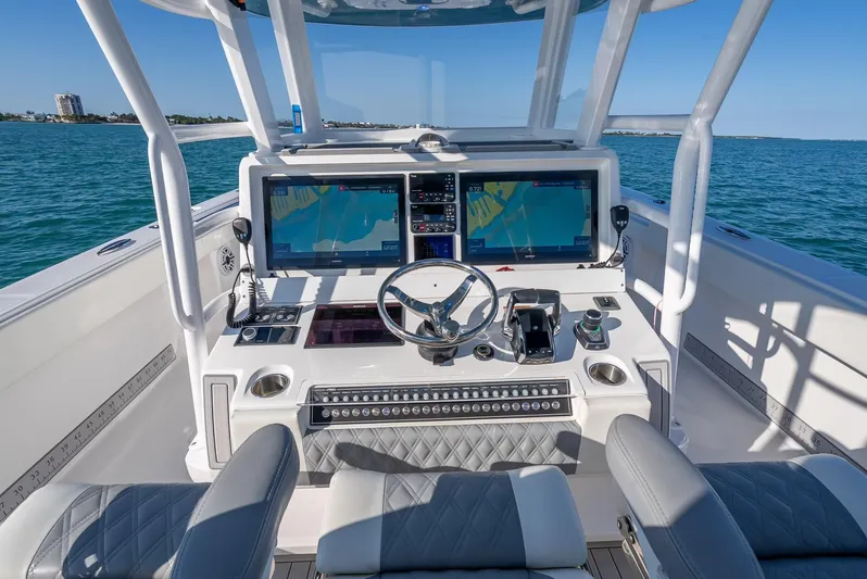  Yacht Photos Pics 2023 Invincible 37 Catamaran helm with dual screens and modern controls on open water.