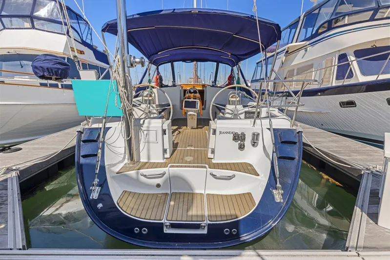 Crazy Horse Yacht Photos Pics Jeanneau Sun Odyssey 52.2 sailboat, 2001 model, docked at marina with blue canopy.