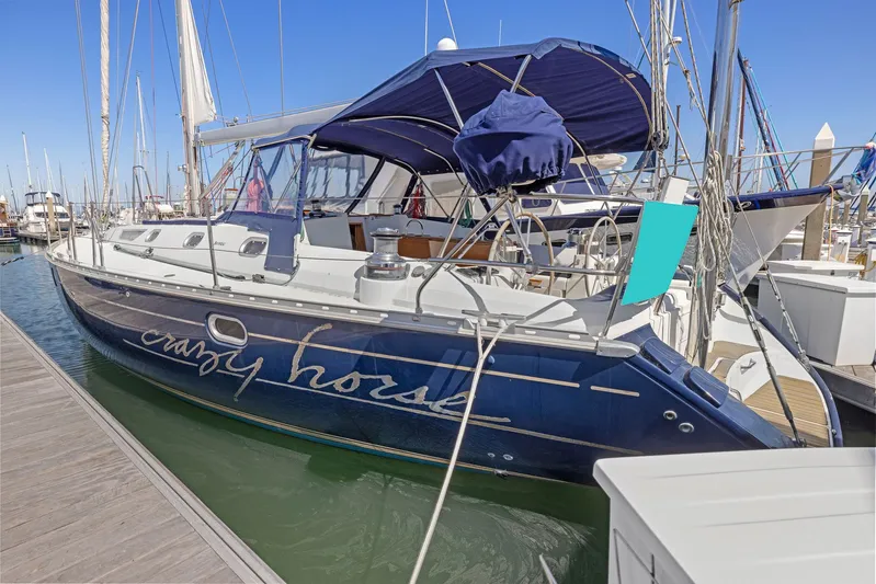 Crazy Horse Yacht Photos Pics Jeanneau Sun Odyssey 52.2 sailboat, 2001 model, docked at marina, blue hull, sunny day.