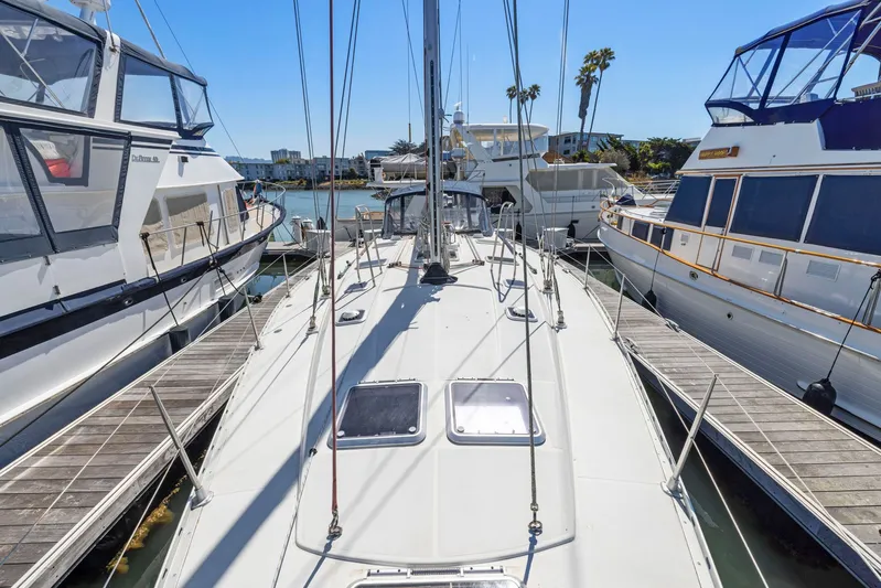 Crazy Horse Yacht Photos Pics Jeanneau Sun Odyssey 52.2 sailboat docked between yachts, sunny marina view.