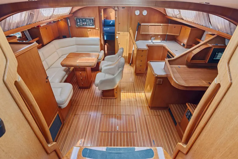 Crazy Horse Yacht Photos Pics Luxurious interior of 2001 Jeanneau Sun Odyssey 52.2 yacht with wood finish and seating area.
