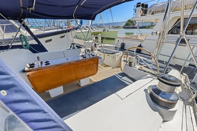 Crazy Horse Yacht Photos Pics Cockpit of 2001 Jeanneau Sun Odyssey 52.2 sailboat, featuring wooden table and steering wheel.