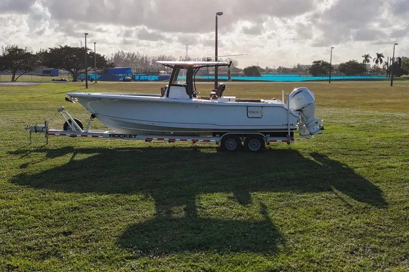  Yacht Photos Pics 2023 Seahunt 30 GameFish Coffin Box boat on trailer in grassy field.