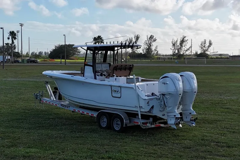  Yacht Photos Pics 2023 Seahunt 30 GameFish Coffin Box boat on trailer in grassy field.