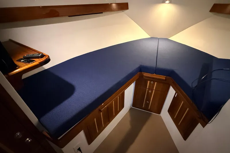 Kapalua Yacht Photos Pics 2013 Ocean Sport Roamer 33 interior cabin with blue cushioned seating and wooden cabinetry.