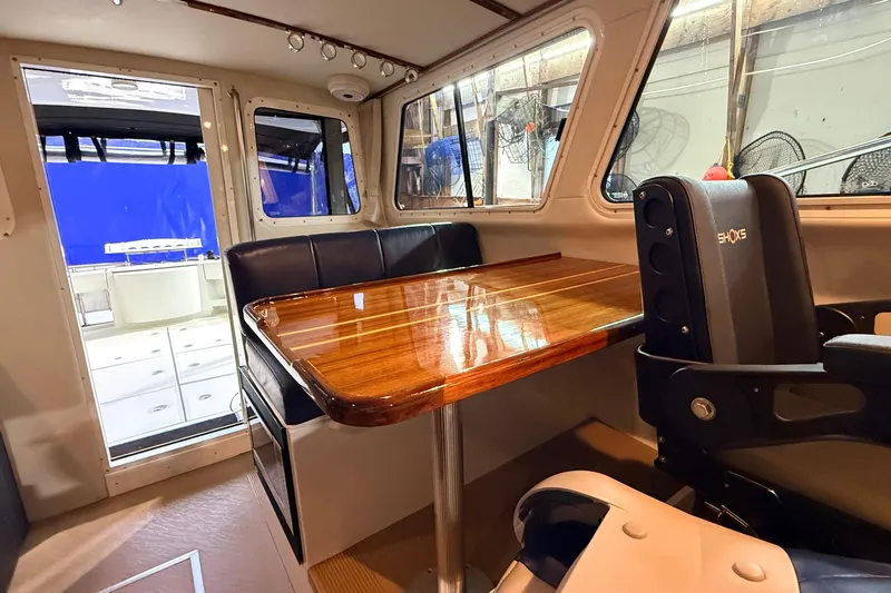 Kapalua Yacht Photos Pics Interior of 2013 Ocean Sport Roamer 33, featuring a polished wooden table and seating area.