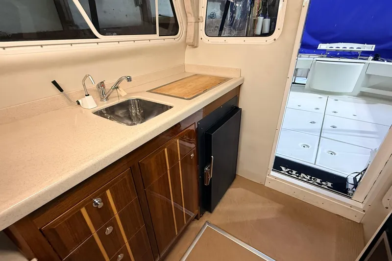 Kapalua Yacht Photos Pics Interior of 2013 Ocean Sport Roamer 33, featuring a compact kitchenette with sink and fridge.