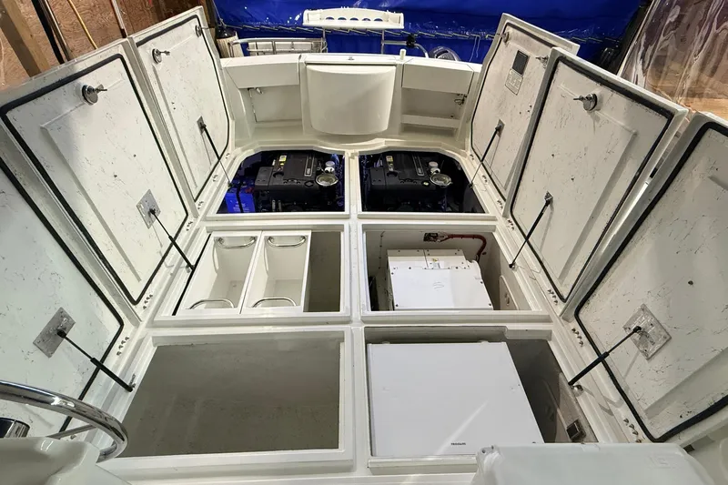 Kapalua Yacht Photos Pics 2013 Ocean Sport Roamer 33 boat interior with open storage compartments and visible engine.