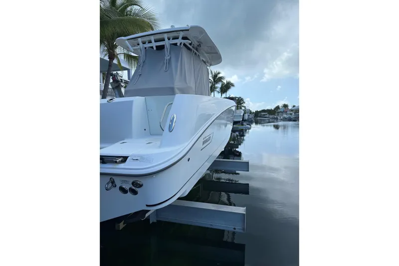  Yacht Photos Pics 2016 Boston Whaler 320 Outrage boat docked by palm trees and calm water.