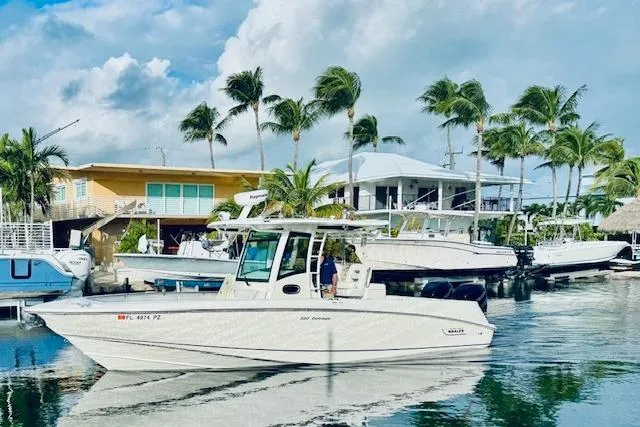  Yacht Photos Pics 2016 Boston Whaler 320 Outrage boat docked near tropical waterfront homes.