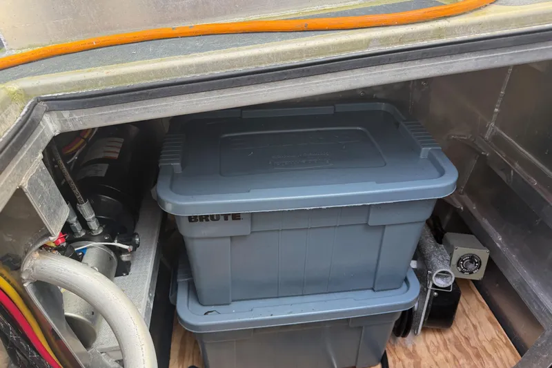 C Lady Yacht Photos Pics Storage compartment in a 2020 Armstrong Marine 35 boat with plastic bins and equipment.