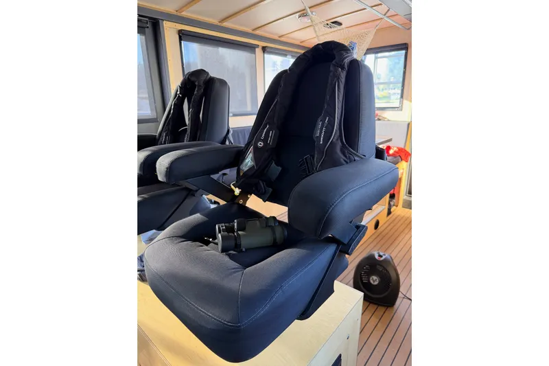 C Lady Yacht Photos Pics Captain's chair inside 2020 Armstrong Marine 35 boat, featuring binoculars and modern interior.