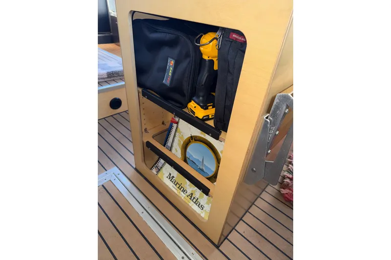 C Lady Yacht Photos Pics Storage compartment on 2020 Armstrong Marine 35, featuring tools and a Marine Atlas.