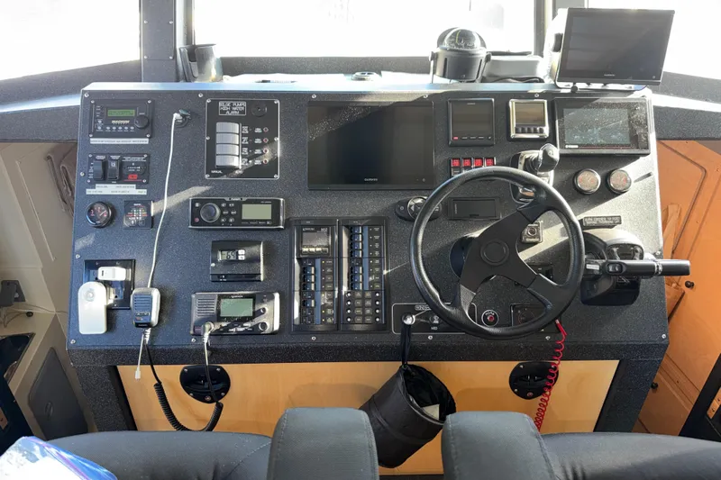 C Lady Yacht Photos Pics Control panel of a 2020 Armstrong Marine 35 boat with steering wheel and navigation equipment.