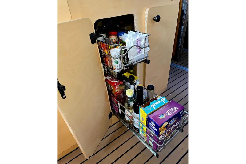 C Lady Yacht Photos Pics Pull-out pantry in 2020 Armstrong Marine 35 boat, stocked with various food items.