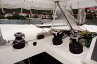 Leopard 50 yacht deck with winches and colorful coastal buildings in the background.