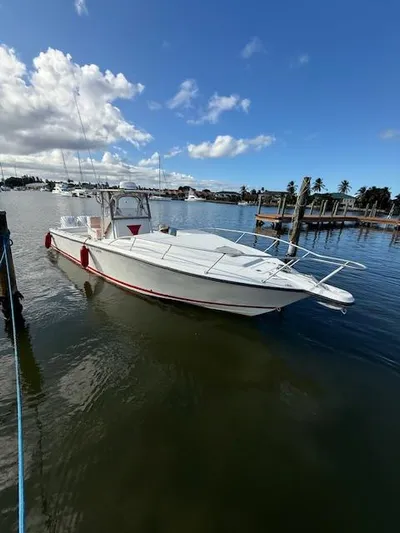 Wapala Yacht Photos Pics 2004 SeaVee 34 Center Console boat docked on calm water under a blue sky.