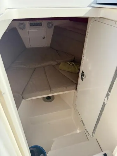 Wapala Yacht Photos Pics 2004 SeaVee 34 Center Console cabin interior with cushioned seating and storage.