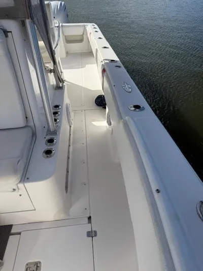 Wapala Yacht Photos Pics 2004 SeaVee 34 Center Console boat deck, featuring rod holders and seating, on calm water.