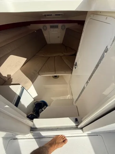 Wapala Yacht Photos Pics 2004 SeaVee 34 Center Console cabin interior with beige cushions and storage space.