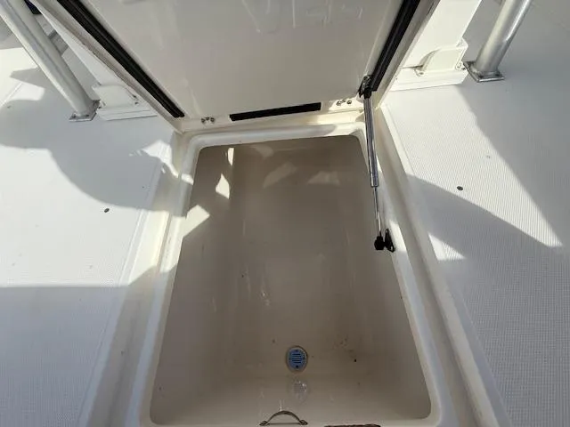 Wapala Yacht Photos Pics 2004 SeaVee 34 Center Console storage compartment, open lid, white interior, sunlight casting shadows.