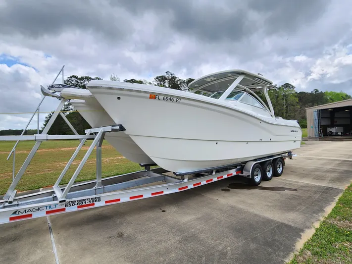  Yacht Photos Pics 2019 World Cat 296DC boat on a trailer, parked outdoors under cloudy skies.