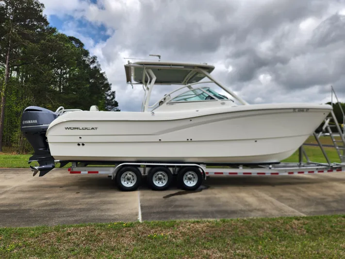  Yacht Photos Pics 2019 World Cat 296DC boat on trailer, parked outdoors under cloudy sky.
