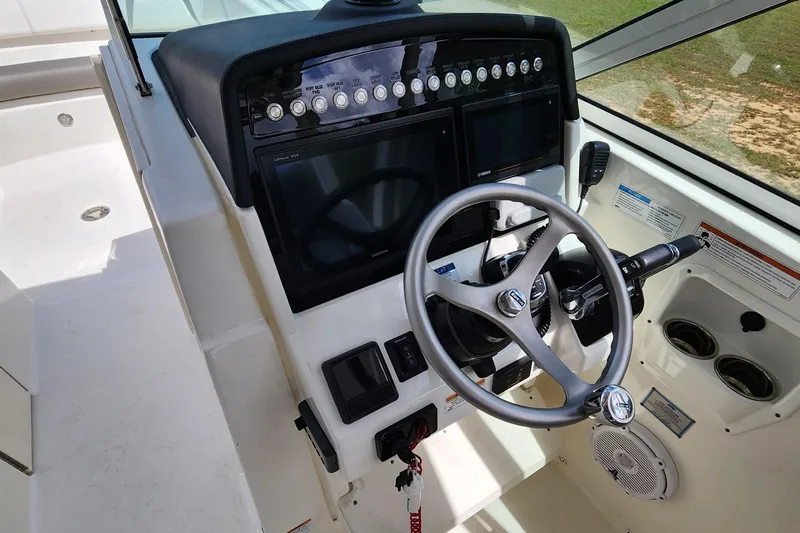  Yacht Photos Pics 2019 World Cat 296DC boat dashboard with steering wheel and control panel.