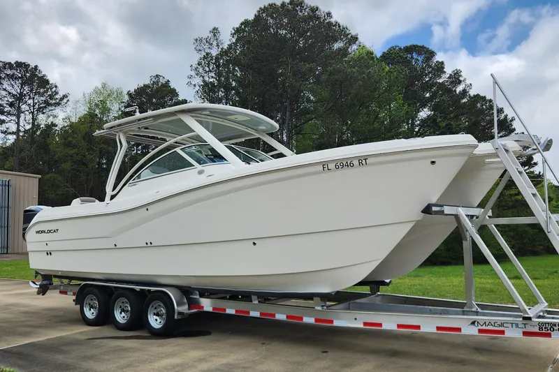  Yacht Photos Pics 2019 World Cat 296DC boat on trailer, parked outdoors with trees in background.