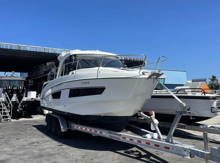  Yacht Photos Pics 2021 Beneteau Antares boat on trailer, parked outdoors under clear blue sky.