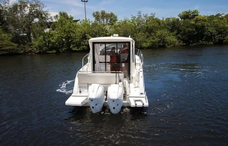  Yacht Photos Pics 2021 Beneteau Antares boat with dual outboard motors on a calm river.