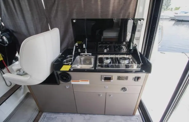  Yacht Photos Pics Compact kitchen area in a 2021 Beneteau Antares boat, featuring a stove and sink.