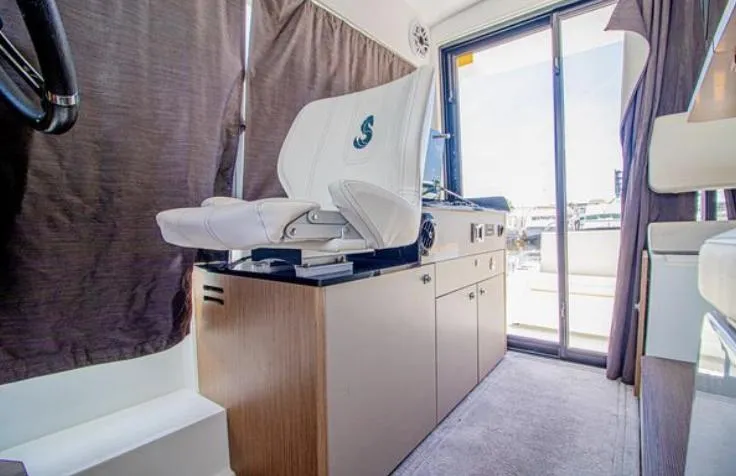  Yacht Photos Pics Interior of 2021 Beneteau Antares boat with helm seat and sliding glass door.