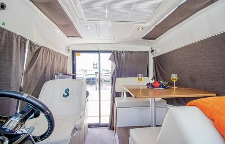  Yacht Photos Pics Interior of 2021 Beneteau Antares boat with dining area and helm.