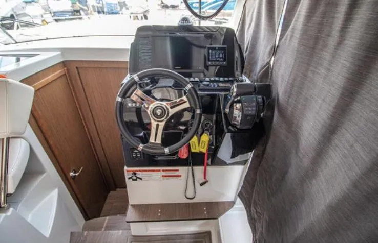  Yacht Photos Pics 2021 Beneteau Antares helm with steering wheel and navigation controls.