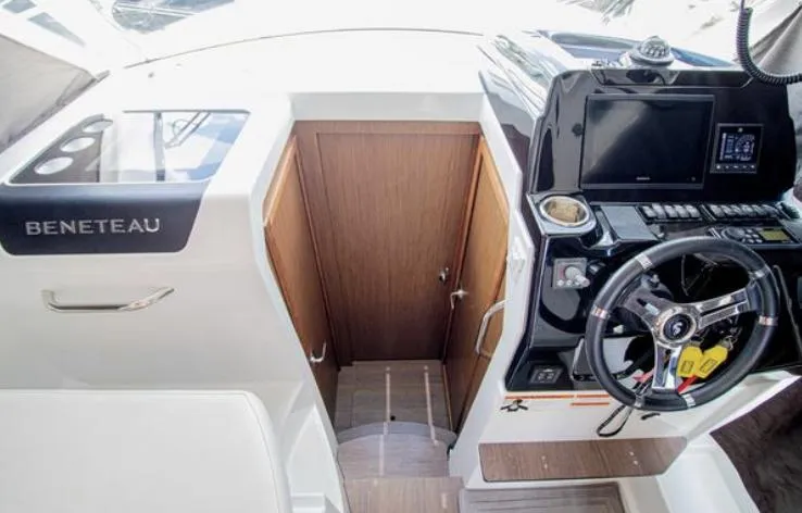  Yacht Photos Pics 2021 Beneteau Antares helm station with modern controls and wooden cabin door.
